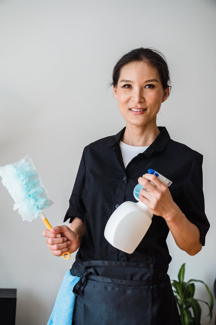 woman in black shirt holding white and blue sprayer bottle